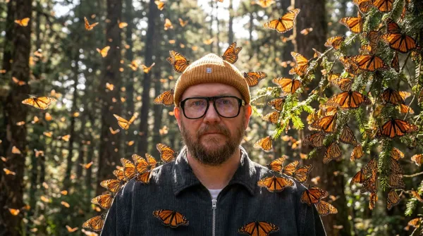 The person standing still in a monarch butterfly